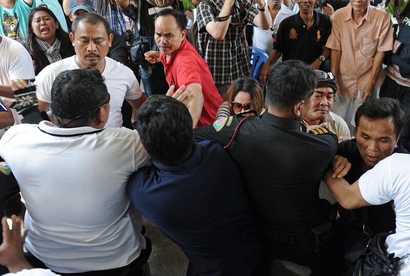 Frustrated Thai voters try to force their way through a line of police officers, including plainclothes officers, blocking the entrance to a polling station as voting was cancelled after anti-government protesters prevented the delivery of election material in Bangkok. AFP