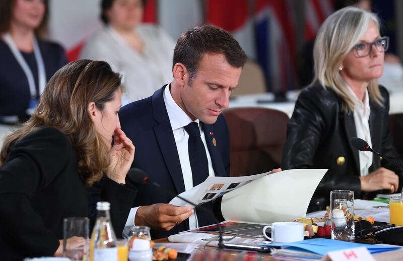 France's President Emmanuel Macron looks at his notes at the G7 Gender Equality Advisory Council Breakfast. Neil Hall / EPA
