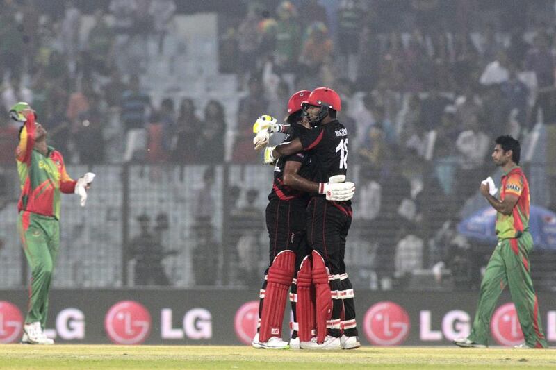 Hong Kong’s Haseeb Amjad, left, and Nadeem Ahmed celebrate after they defeated Bangladesh by two wickets during their World Twenty20 match in Chittagong. Bikas Das / AP Photo