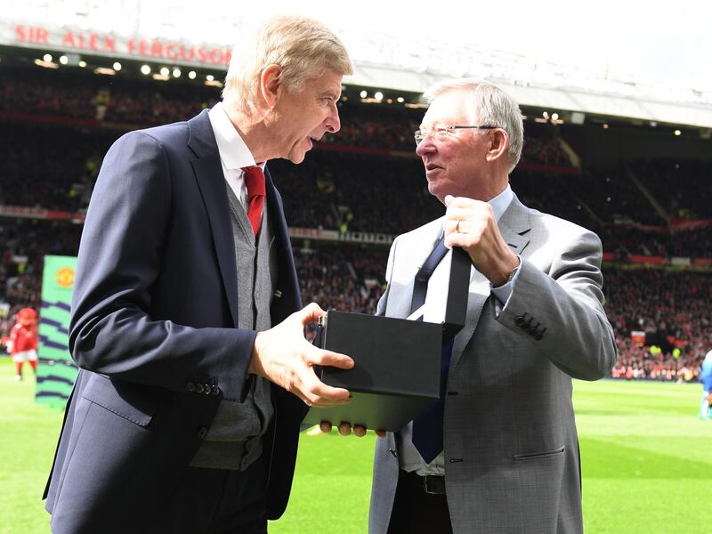 MANCHESTER, ENGLAND - APRIL 29:  Former manager Sir Alex Ferguson of Manchester United presents Manager Arsene Wenger of Arsenal with a gift to mark his retirement ahead of the Premier League match between Manchester United and Arsenal at Old Trafford on April 29, 2018 in Manchester, England.  (Photo by Stuart MacFarlane/Arsenal FC via Getty Images)