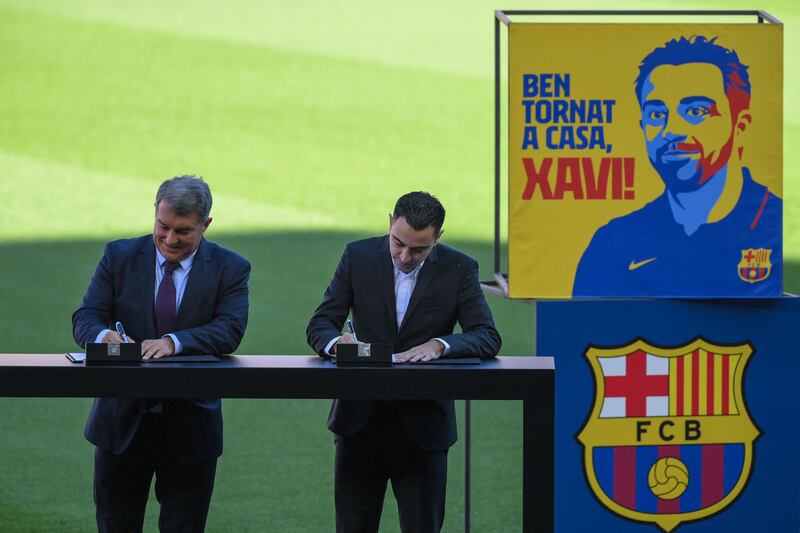 Xavi Hernandez and Joan Laporta sign the contract to confirm Xavi as the next Barcelona manager. AFP