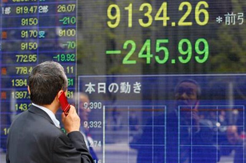 A man speaks on a mobile phone in front of a securities firm's electronic stock board in Tokyo, Monday, May 7, 2012. Asian stock markets were pummeled Monday by weekend election results in Greece and France that heightened uncertainty about Europe's ability to solve its debt crisis. Japan's Nikkei 225 index plunged 2.6 percent to 9,134.26. (AP Photo/Shizuo Kambayashi) *** Local Caption ***  Japan World Markets.JPEG-0249b.jpg