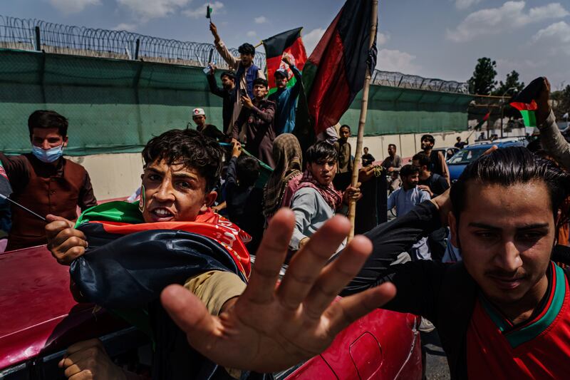 Anti-Taliban protesters mark Afghanistan's independence day by attempting to hoist the red, green and black national banner.  By Marcus Yam. Los Angeles Times/EPA