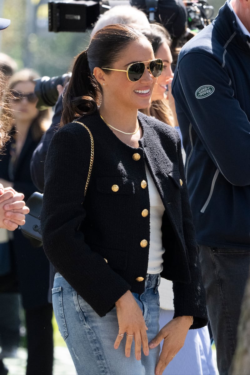 Meghan pairs a cropped tweed Celine jacket with aviator sunglasses and light-wash jeans. AP