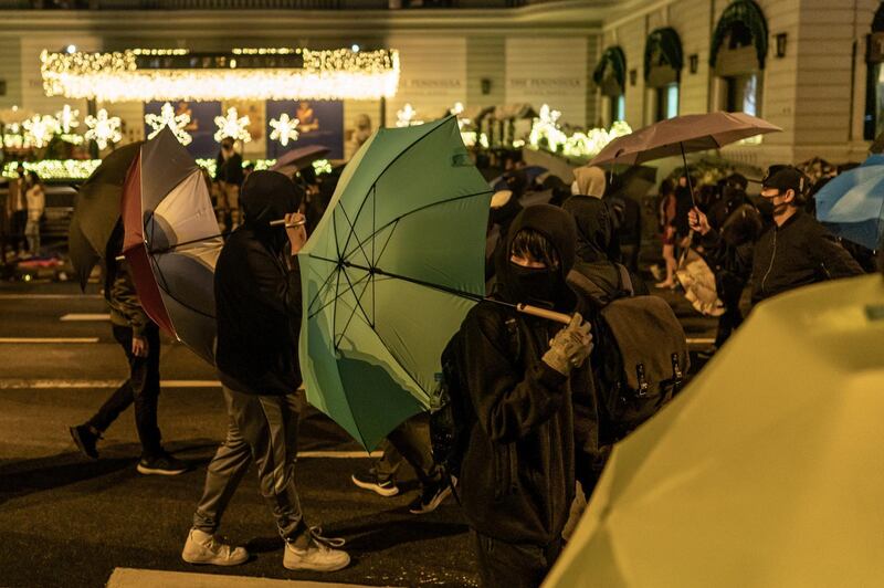 Protesters fall back as they hold umbrellas on December 24, 2019 in Hong Kong, China. Anthony Kwan/Getty Images