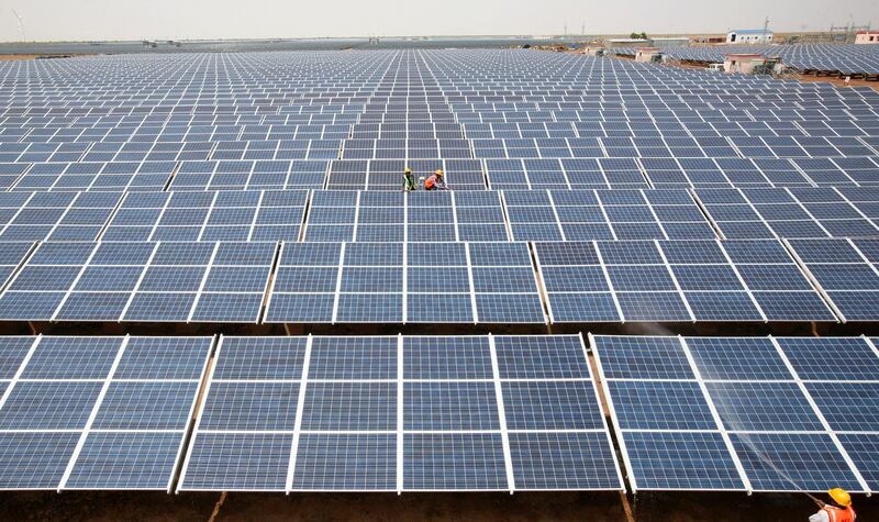 FILE PHOTO: Workers install photovoltaic solar panels at the Gujarat solar park under construction in Charanka village in Patan district of the western Indian state of Gujarat, India, April 14, 2012. REUTERS/Amit Dave/File photo