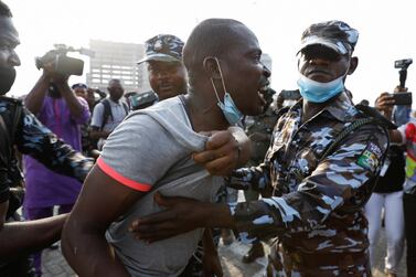 Police officers detain a man during a protest against the reopening of the Lekki toll gate in Lagos. Reuters