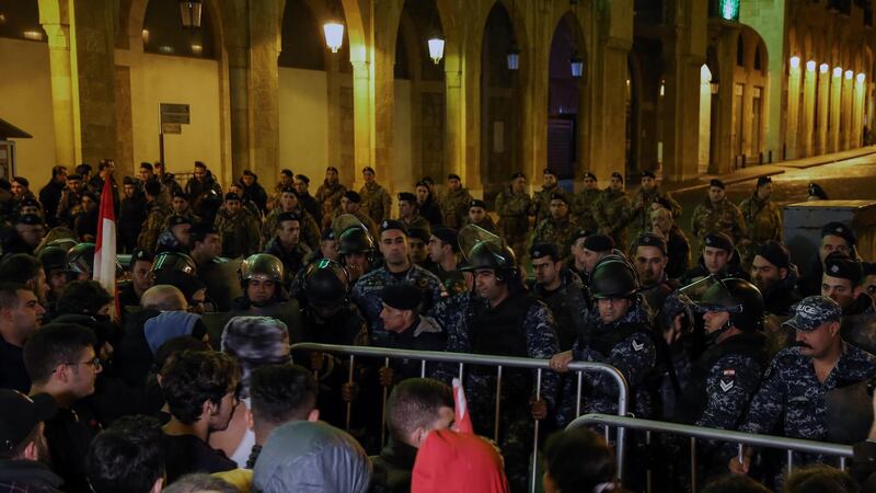 Lebanese policemen stand guard at the entrance to the Parliament building during an anti-government protest in front the entrance of Parliament building in Beirut.  EPA