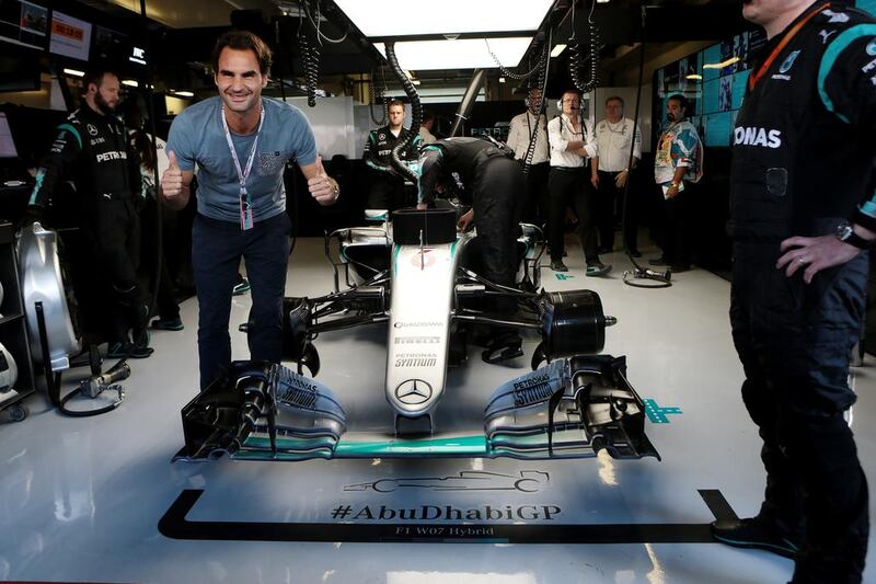 Tennis player Roger Federer poses with the car of Nico Rosberg of Germany and Mercedes-GP ahead of the Abu Dhabi Formula One Grand Prix at Yas Marina Circuit in Abu Dhabi on November 27, 2016. Christopher Pike / The National