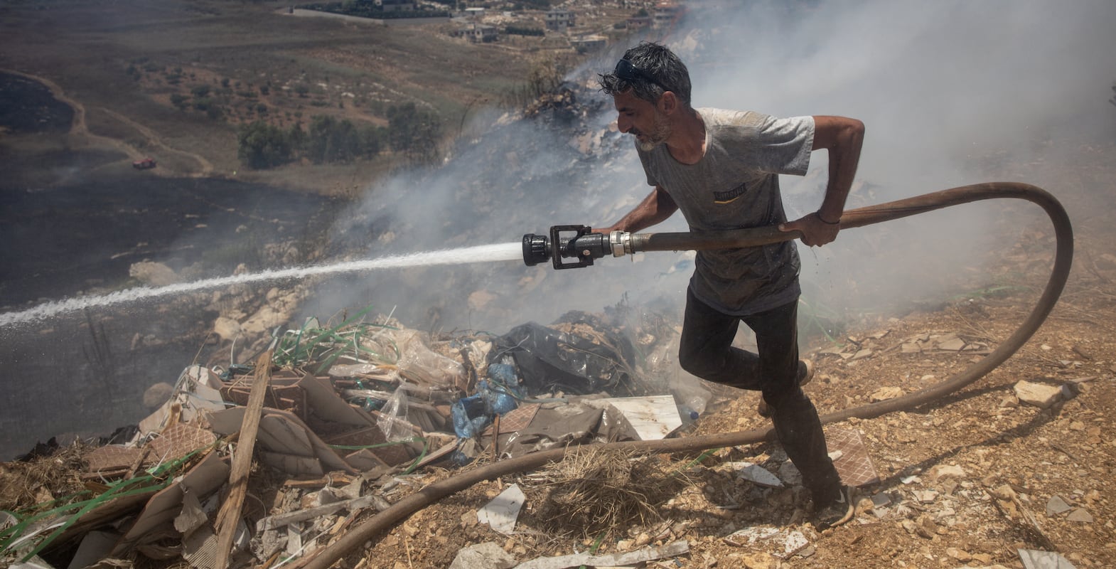 A civilian tries to put out fires caused by multiple Israeli strikes that hit targets next to the towns main road on June 26, 2024 in Bint Jbeil, Lebanon. Getty Images