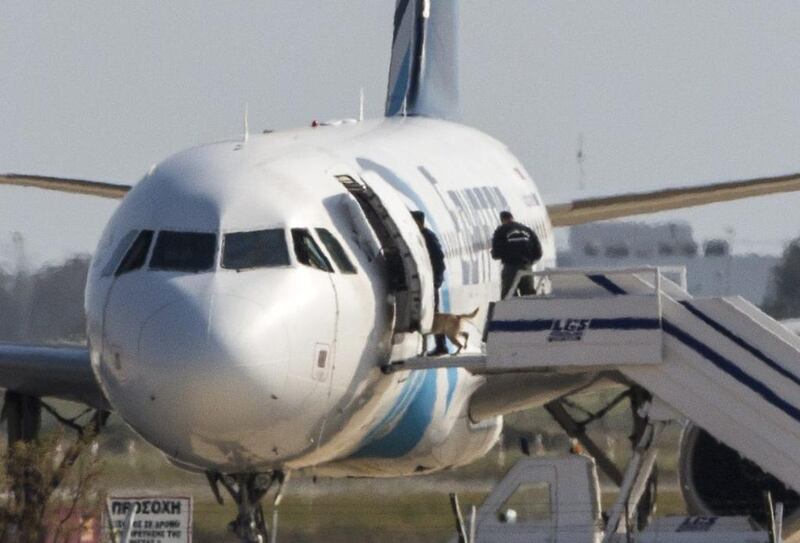 Cypriot security forces take a sniffer dog into an EgyptAir Airbus A320 parked at the tarmac of Larnaca airport after the six-hour hijacking of the plane came to an end on March 29, 2016. Behrouz Mehri/ AFP Photo