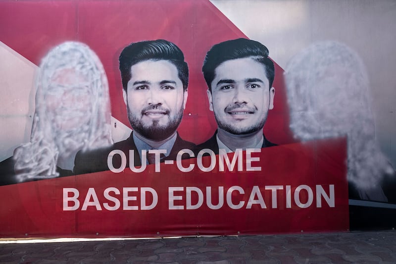 A banner, with images of women defaced using spray paint, at a university in Kabul. Male students have started back at Afghan universities but women remain barred. AFP