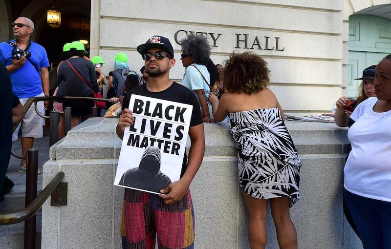 An activist holds a Black Lives Matter poster on the steps of Los Angeles City Hall (AFP / Frederic J. BROWN)