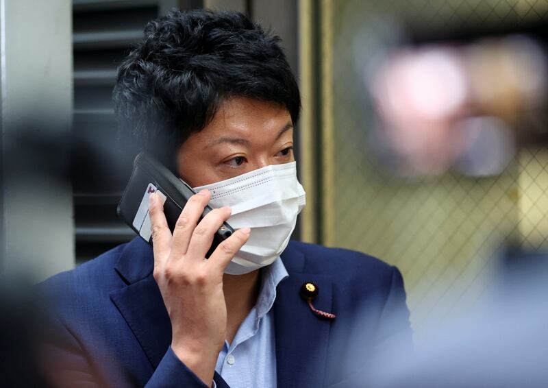 The Constitutional Democratic Party of Japan lawmaker Taiga Ishikawa uses his smartphone after he tried to meet with Belarusian sprinter Krystsina Tsimanouskaya at Haneda international airport, in Tokyo, Japan.