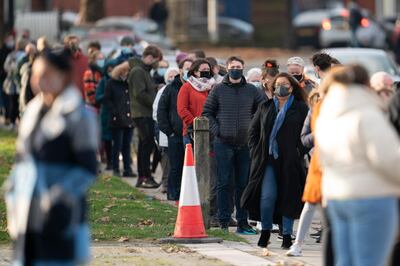 Members of the public queue at Wavertree Sports Park in Liverpool on the first day of the pilot scheme of mass coronavirus testing in Liverpool, Friday Nov. 6, 2020. Liverpool is the pilot project for possible weekly testing of the entire population covering up to 10 million people across England a day. ( AP Photo/Jon Super)
