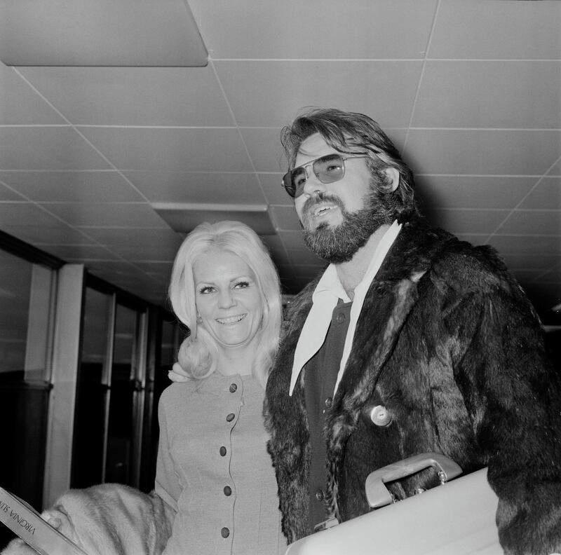 American singer, songwriter, actor, record producer, and entrepreneur Kenny Rogers with his wife Margo Anderson at Heathrow Airport, London, UK, 24th March 1970. (Photo by Evening Standard/Hulton Archive/Getty Images)