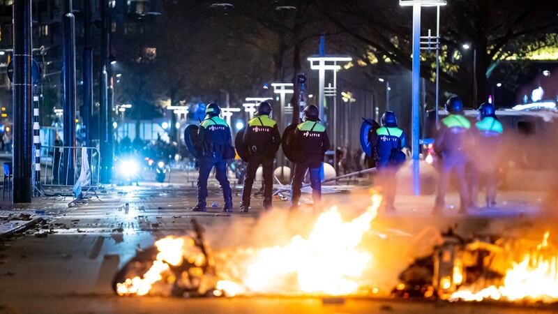 Police react after protesters set fires in the Dutch city of Rotterdam. EPA