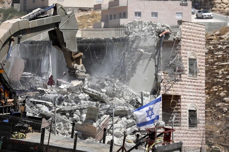 An Israeli army excavator machine demolishes a building in the Palestinian village of Sur Baher, in East Jerusalem.  EPA