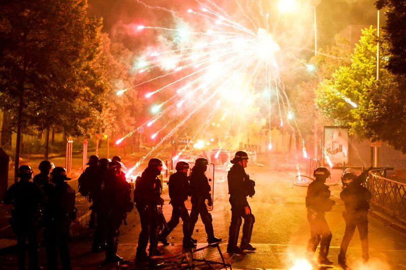 Fireworks go off during clashes between police and protesters. Reuters