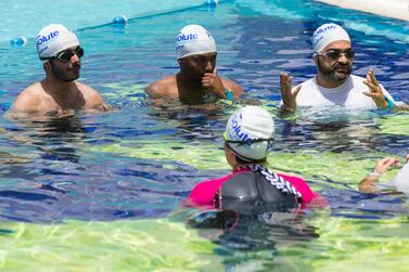 Adult men learn how to swim at an Absolute Swimming Academy class in Dubai. Christopher Pike / The National