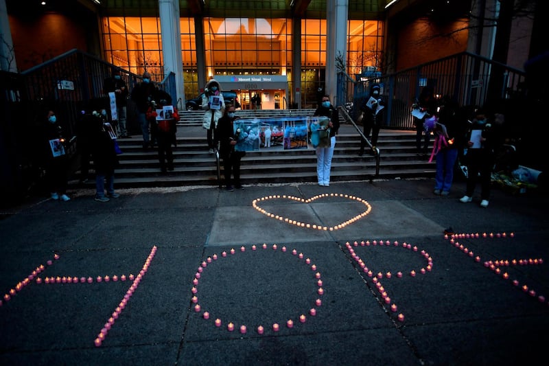 Nurses and healthcare workers formed the word "Hope" with candles as they mourn and remember colleagues who died during the outbreak of coronavirus outside Mount Sinai Hospital in Manhattan, New York City. AFP