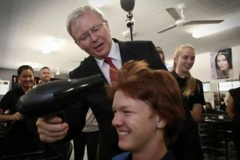 Australian Prime Minister Kevin Rudd dries the hair of Ryan Rosenberger at St Columan's College in Caboolture, Queensland.