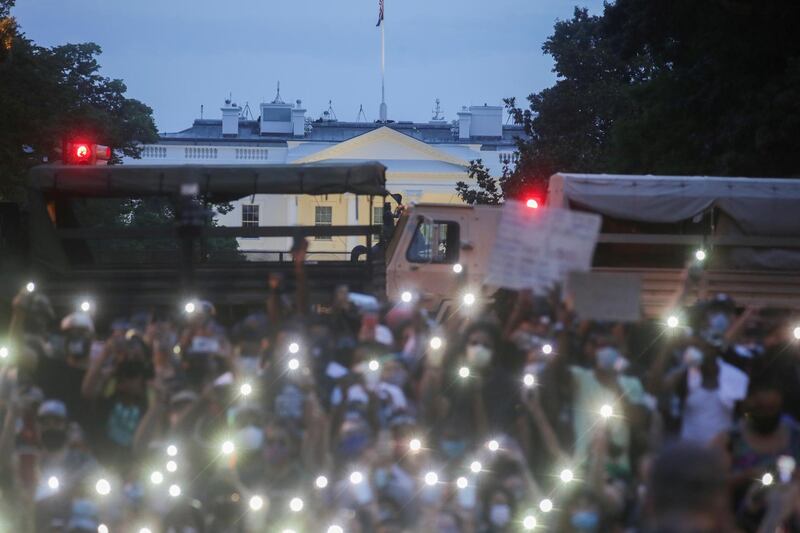 Demonstrators use the light of their cellphones as they gather during a protest against the death in Minneapolis police custody of George Floyd, near the White House in Washington, US. Reuters
