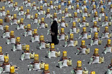 A woman walks between food rations provided by a local charity to conflict-affected people in Sanaa. EPA