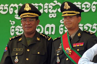 Cambodia's prime minister Hun Sen (L) poses with his son Hun Manet during a ceremony at a military base in Phnom Penh, on October 13, 2009. AFP