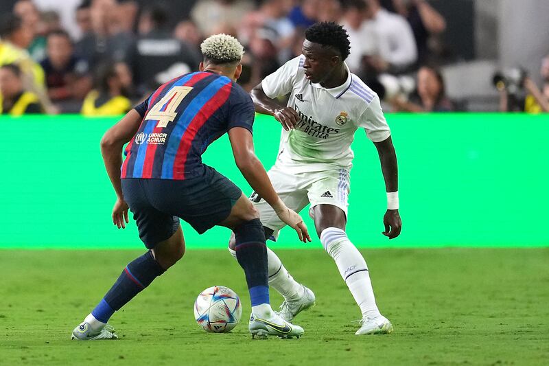 Real Madrid forward Vinicius Jr controls the ball against Barcelona defender Ronald Araujo. USA Today