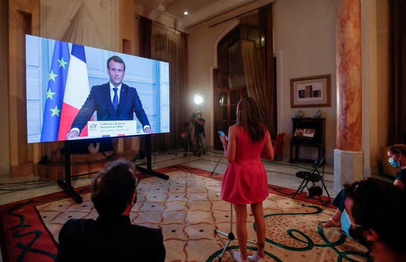 French President Emmanuel Macron listens to a Lebanese journalist's questions during a virtual press conference broadcast at the Pine Residence, the official residence of the French ambassador, in Beirut.  AFP