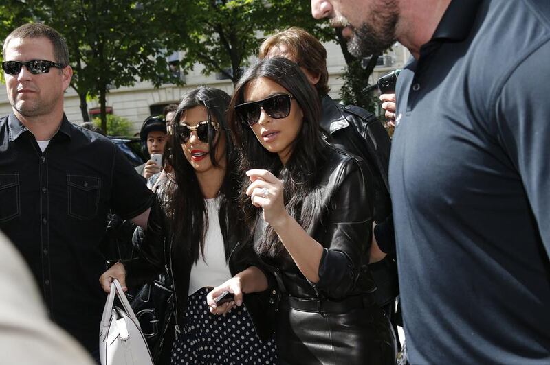 Body guards escort TV personality Kim Kardashian, right, and her sister Kourtney, who walk in the street as they visit fashion shops in Paris on May 22, 2014. Gonzalo Fuentes / Reuters