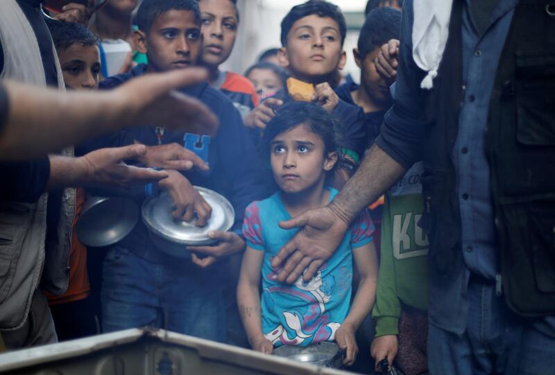 Palestinians wait to get soup offered for free in Gaza City. Reuters