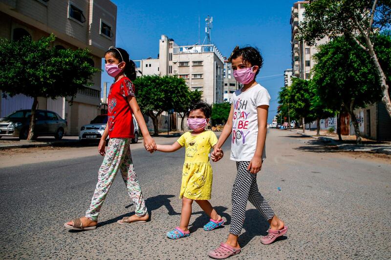 Children cross an empty street amid the lockdown imposed to limit the spread of the pandemic in Gaza City.   AFP