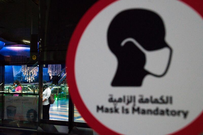 A sign makes Covid-19 instructions clear, as a passenger waits for a train on the Dubai Metro. AP Photo