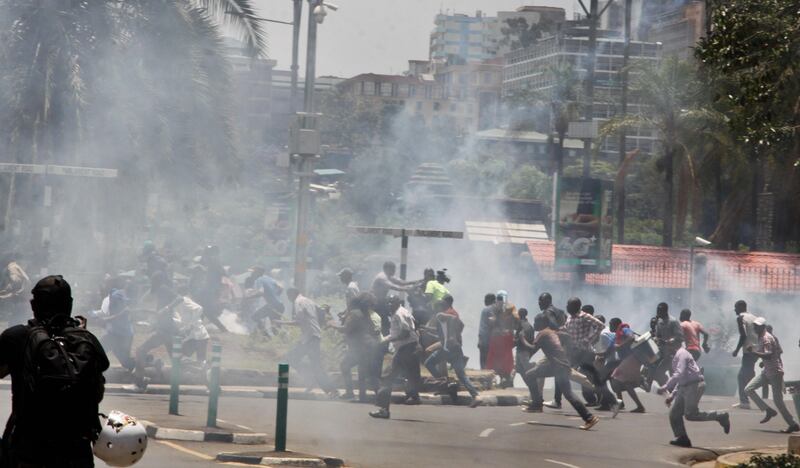 Opposition supporters protesting over the upcoming elections, and passersby, run from a cloud of tear gas fired by riot police in downtown Nairobi, Kenya Monday, Oct. 16, 2017. Two international human rights groups said Monday that Kenya's police in August attacked opposition supporters killing dozens and injuring scores following demonstrations protesting President Uhuru Kenyatta's subsequently annulled re-election. (AP Photo/Khalil Senosi)