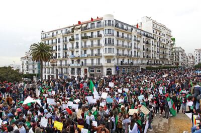 TOPSHOT - Algerians carry placards and national flags as they take part in a demonstration in the capital Algiers against President Abdelaziz Bouteflika on March 19, 2019.  Bouteflika today confirmed he will stay in power beyond his term expiring next month, despite tens of thousands of people demonstrating against his rule. / AFP / STRINGER
