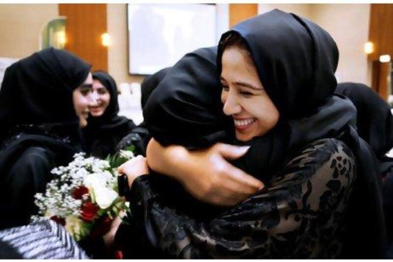 Amal Al Mutawa, right, one of the volunteer mentors for the Injaz initiative, congratulates members of the winning team. Delores Johnson / The National