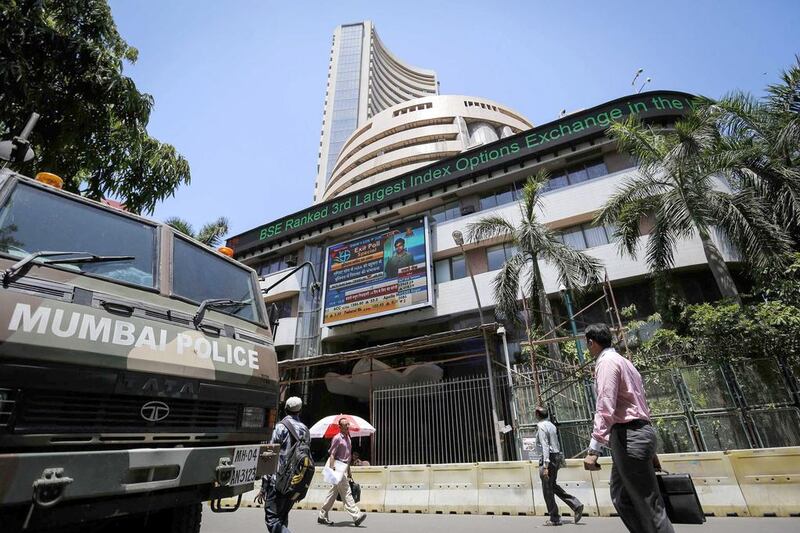 People walk past the Bombay Stock Exchange (BSE) building in Mumbai on May 13, 2014. Indian shares rose as much as 2.2 per cent on Tuesday, a third consecutive record high, as stocks of companies focussed on the domestic sector surged after exit polls showed the Bharatiya Janata Party and its allies winning a majority in the elections. Danish Siddiqui / Reuters