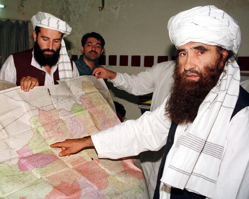 FILE PHOTO - Jalaluddin Haqqani (R), the Taliban's Minister for Tribal Affairs, points to a map of Afghanistan during a visit to Islamabad, Pakistan, October 19, 2001, as his son Naziruddin (L) looks on. REUTERS/Stringer/File Picture