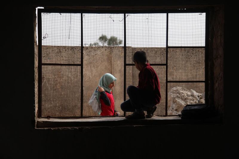 Pupils gather in front of a classroom at a school in the Syrian city of Harim, Idlib province.  AFP