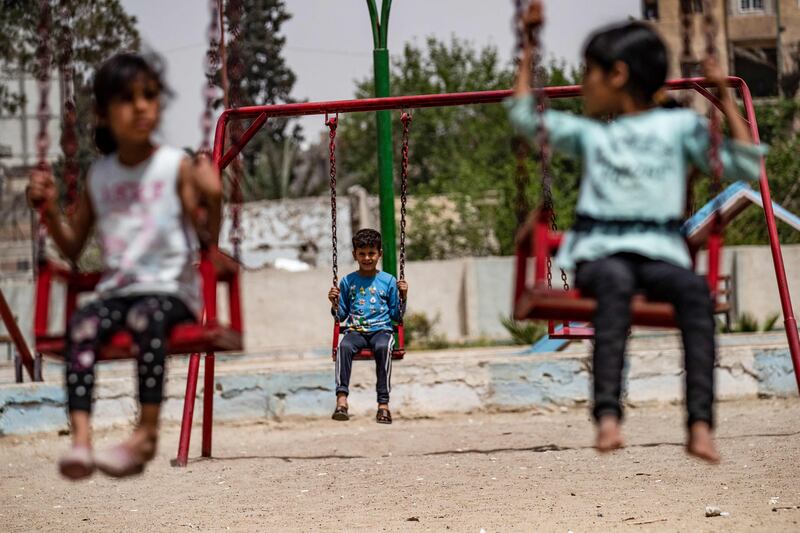 Syrian children play in a refurbished playground in the northern city of Raqa. AFP