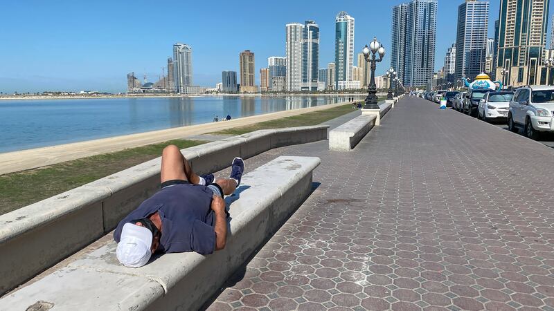 A man takes a short nap on the Buhaira Corniche.