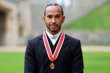 Mercedes' British F1 driver Lewis Hamilton poses with his medal after being appointed as a Knight Bachelor (Knighthood) for services to motorsports, by the Britain's Prince Charles, Prince of Wales, during a investiture ceremony at Windsor Castle in Windsor, west of London on December 15, 2021.  - Lewis Hamilton received his knighthood on Wednesday as the British driver comes to terms with controversially losing the Formula One world title.  (Photo by Andrew Matthews  /  POOL  /  AFP)