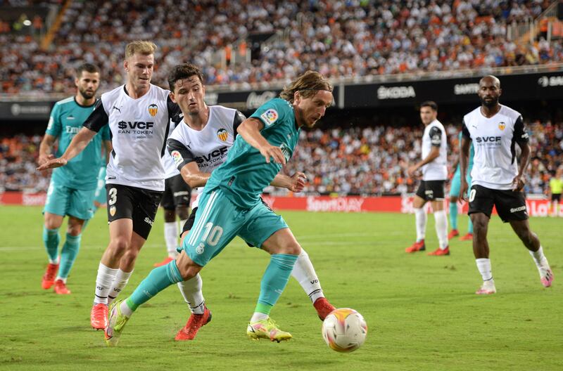 Real Madrid midfielder Luka Modric attempts to move the ball clear of Valencia's Hugo Guillamon. Getty Images