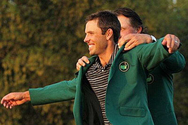 Phil Mickelson presents Charl Schwartzel with the winner's green jacket in Augusta, Georgia. Jamie Squire / Getty Images