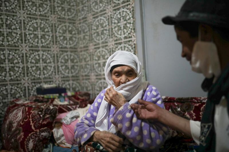 Belhussein Abdelsalam talks with his mother in their home  in Sale, near Rabat, after his day's work as a Charlie Chaplin impersonator. AP Photo