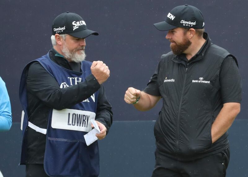 Lowry bumps fists with his caddie as they wait to play the 1st hole. AP Photo