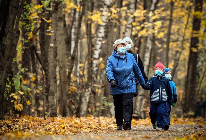 A family wearing face masks walks in a park in Moscow. AFP