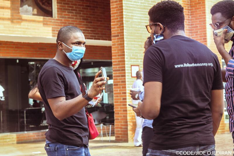 Hamzat Lawal (first on left with a mask), founder of Follow The Money and CEO of Connected Development,  chats to his team during a meeting in Abuja. Courtesy CODE/Jide Ojediran
